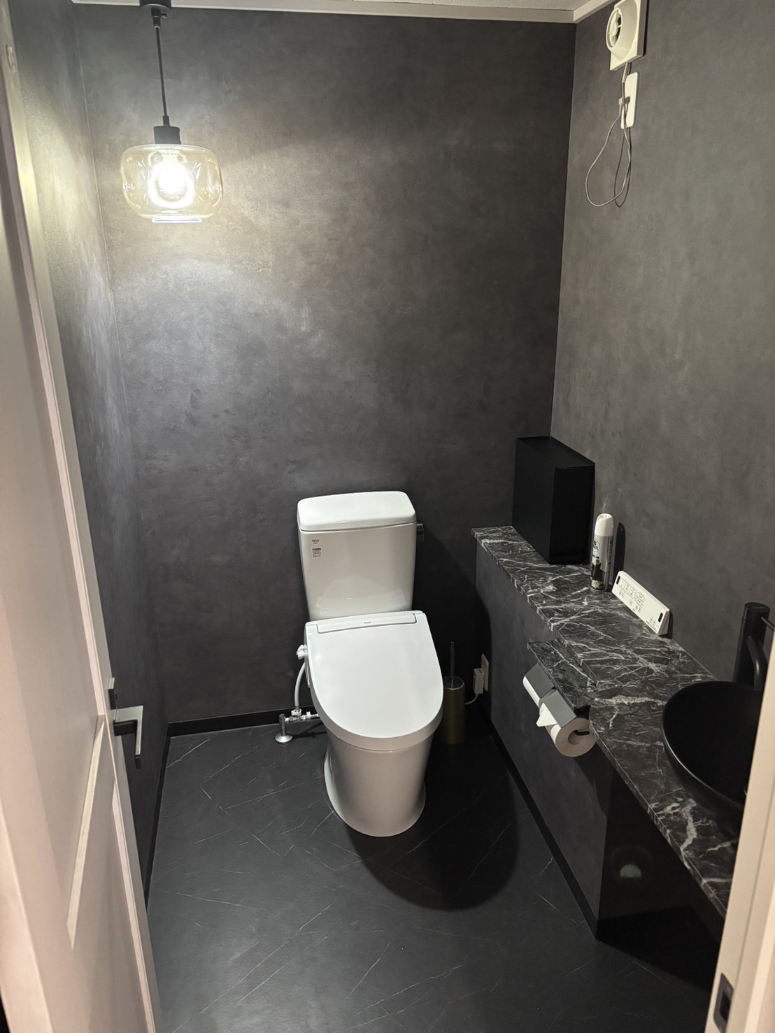 神奈川県相模原市中央区鹿沼台の美容室リニューアル工事施工後のトイレ。黒系で統一した落ち着きのある内装空間。