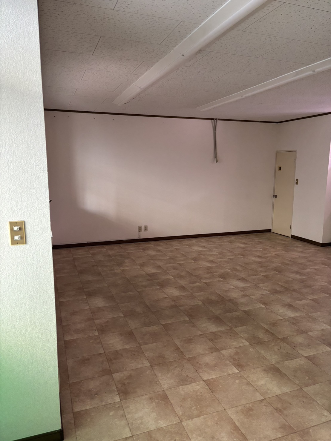 神奈川県相模原市中央区鹿沼台の美容室リニューアル工事施工前の店内。広いスペースと既存壁面の状態が分かる写真。